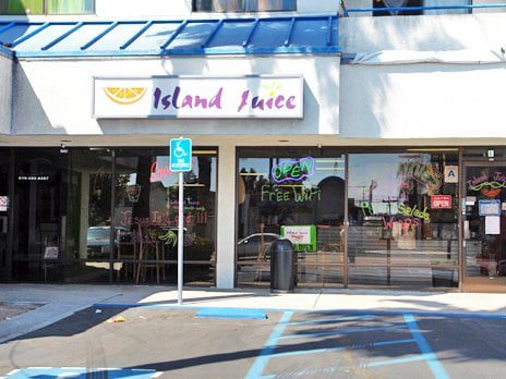 A restaurant with a blue parking sign and a white building