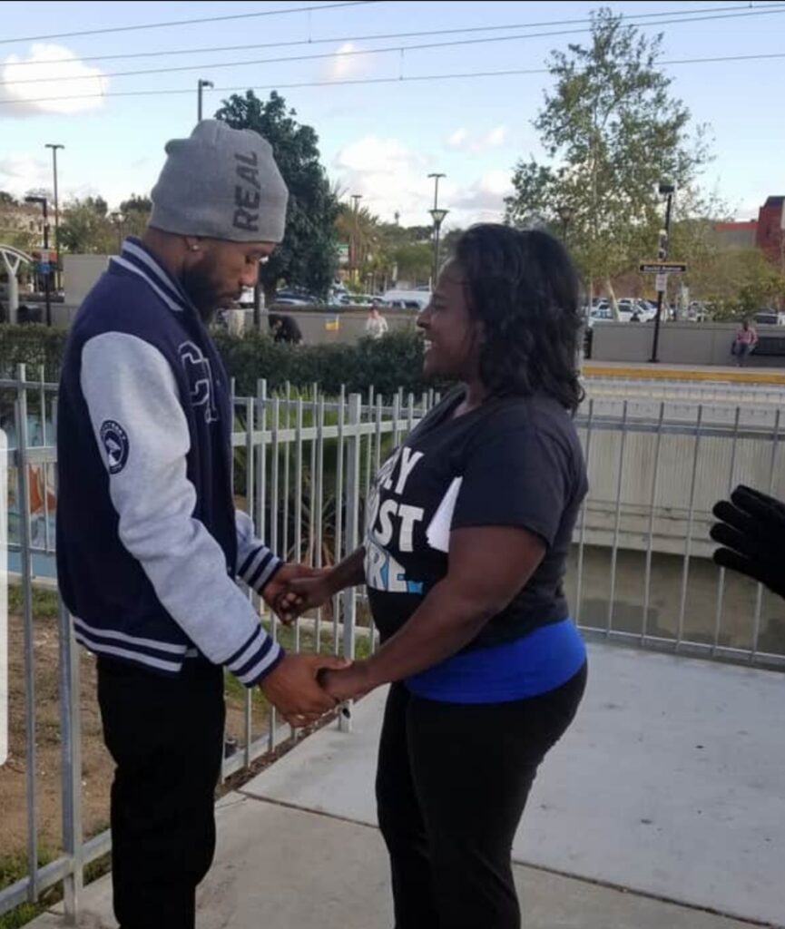 A man and woman holding hands on the side of a bridge.