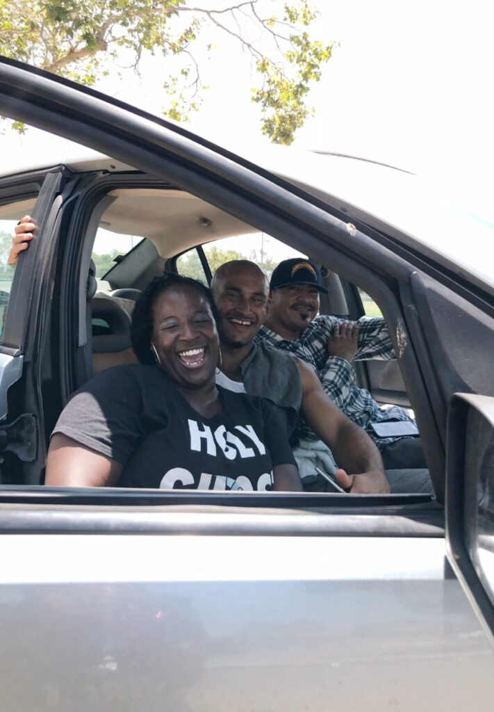 Three people in a car smiling for the camera.