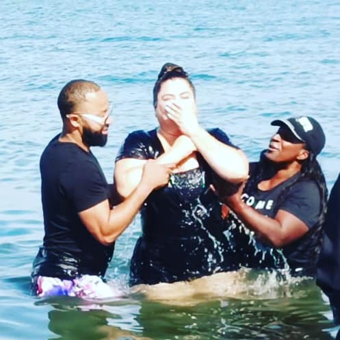 A group of people in the water with one woman crying.